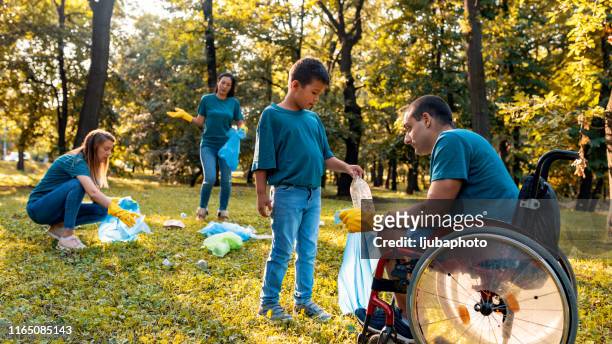 photo of volunteers cleaning park - disability collection stock pictures, royalty-free photos & images