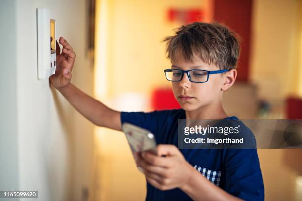 liten pojke para ihop smartphone med skarp hem system - porttelefon bildbanksfoton och bilder
