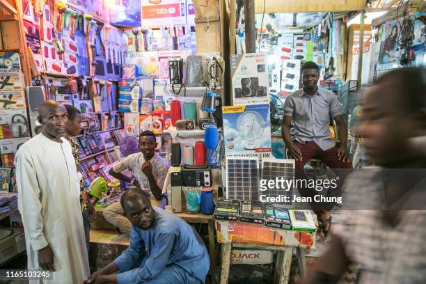 Clerks and guests sit around the electronics shops that sell solar panels and other items inside a market on May 1, 2019 in Maiduguri, Nigeria....