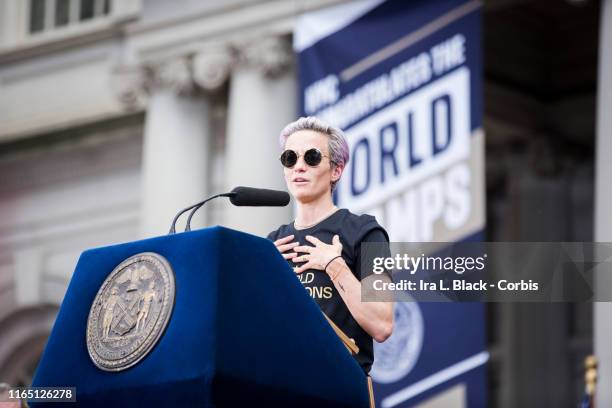 Megan Rapinoe of United States holds her hands to her chest as she addresses the crowd during the ceremony on the steps of City Hall after the ticker...