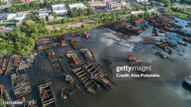 boat graveyard at the shore of staten island, new york city, usa. aerial panoramic photo made by the drone. - boat graveyard stock pictures, royalty-free photos & images