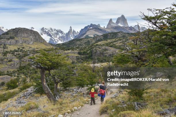 young woman and young boy hiking in front of mountain range with monte fitz roy near el chalten, national park los glaciares, province santa cruz, patagonia, argentina - santa cruz province argentina stockfoto's en -beelden
