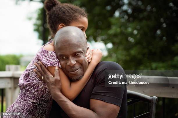 young girl with autism hugging father outdoors. - developmental disability stock pictures, royalty-free photos & images