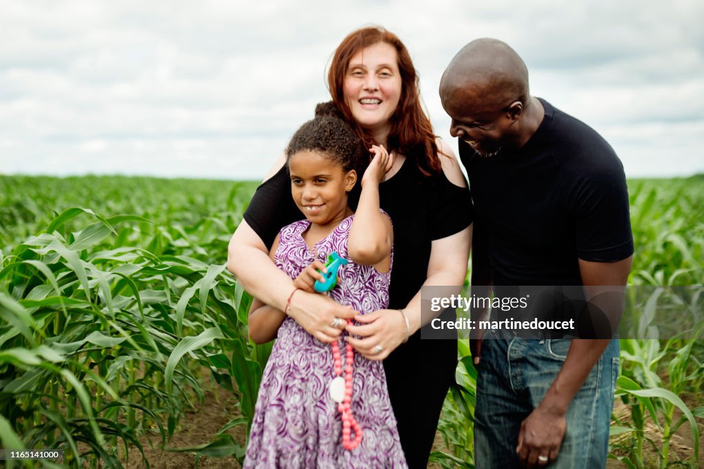 Portrait of mixed-race family with autist daughter in nature.