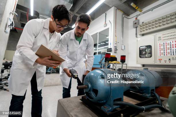 male students taking measurements of a motor pump with an electronic equipment - engeneer student electronics stock pictures, royalty-free photos & images