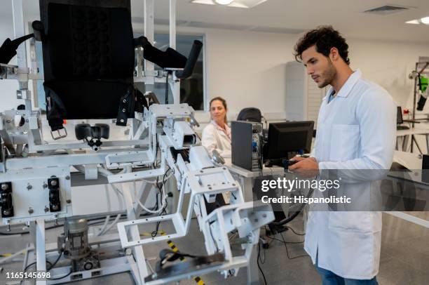 estudiantes masculinos en el laboratorio de mecatrónica moviendo un equipo - mechatronics fotografías e imágenes de stock