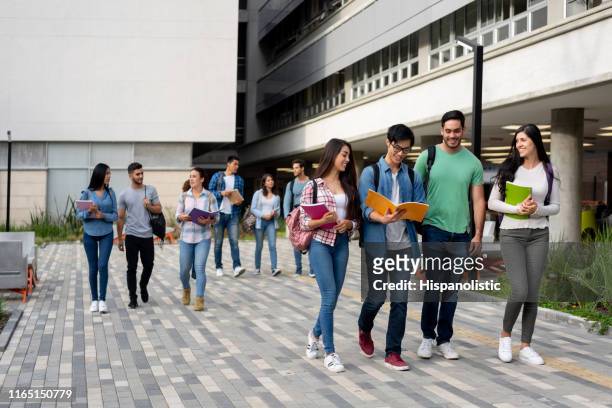 jonge latijns-amerikaanse studenten verlaten de universiteitscampus na een dag van klasse - campus stockfoto's en -beelden