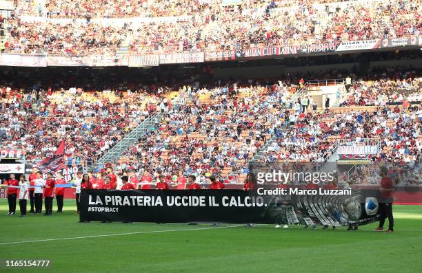Children hold a banner with the inscription 'Piracy kills football' before the Serie A match between AC Milan and Brescia Calcio at Stadio Giuseppe...