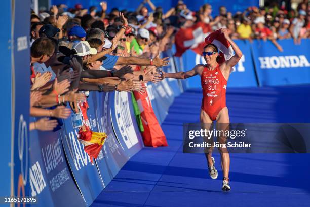 Nicola Spirig of Swiss celebrates with Swiss fans during the women's elite olympic race at the ITU World Triathlon Grand Final on August 31, 2019 in...