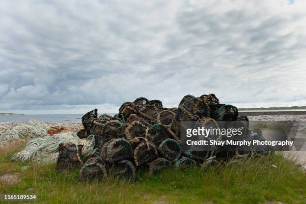 lobster pots piled up by the sea - waterford stock-fotos und bilder