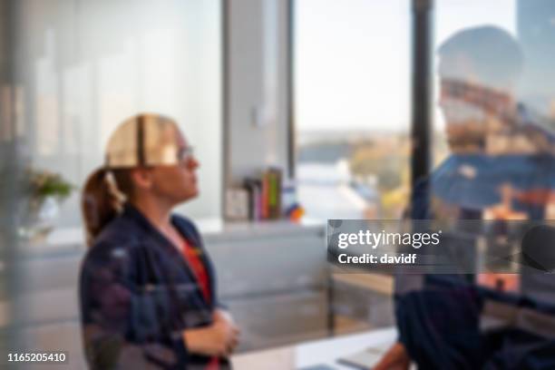 uomo d'affari e donna sfocati in piedi a parlare in un ufficio - high key foto e immagini stock