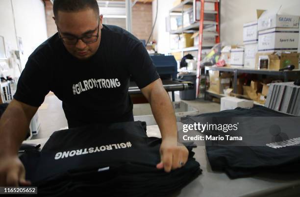 Worker sorts new '#GILROYSTRONG' t-shirts at Cal Silk two days after a mass shooting at the Gilroy Garlic Festival on July 30, 2019 in Gilroy,...