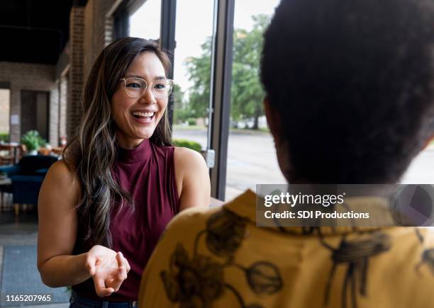 smiling woman talks with friend - corporate storytelling stock pictures, royalty-free photos & images