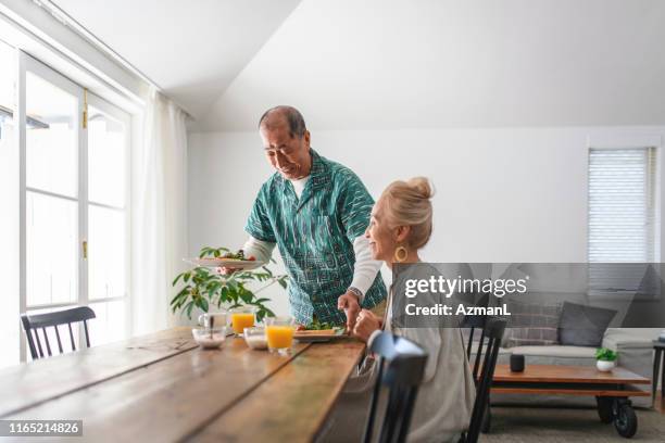 senior japansk man levererar frukost till bordet - japanese fat man bildbanksfoton och bilder