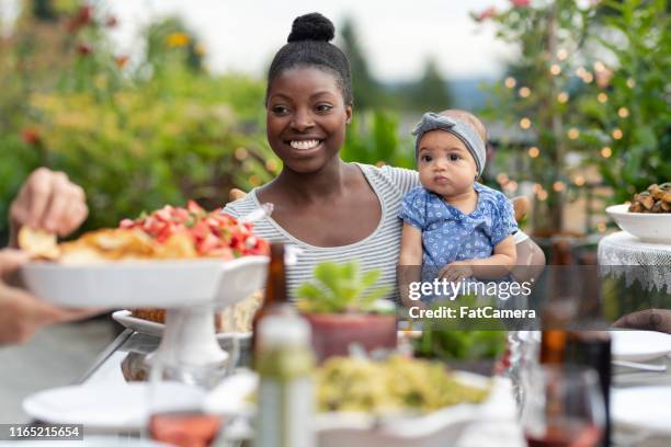 un grupo de amigos adultos jóvenes cenando al aire libre en un patio - filipino family dinner fotografías e imágenes de stock