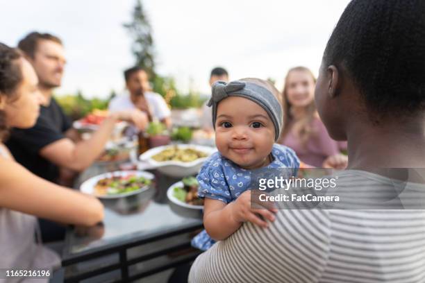 eine gruppe junger erwachsener freunde, die im freien auf einer terrasse essen - black mother and child cooking stock-fotos und bilder