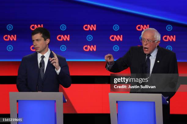 Democratic presidential candidate Sen. Bernie Sanders speaks while South Bend, Indiana Mayor Pete Buttigieg raises his hand during the Democratic...