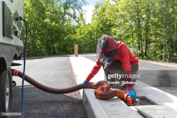 woman emptying rv sewer after camping - dustman stock pictures, royalty-free photos & images