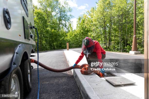 woman emptying rv sewer after camping - trailer trash stock pictures, royalty-free photos & images