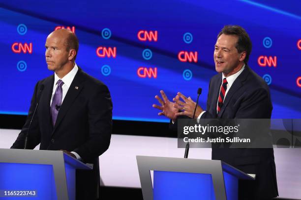 Democratic presidential candidate Montana Gov. Steve Bullock speaks while former Maryland congressman John Delaney listens during the Democratic...