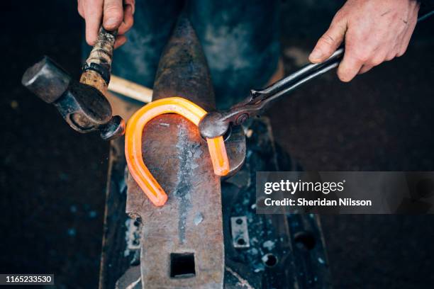farrier, blacksmith fitting horseshoes - smeden stockfoto's en -beelden