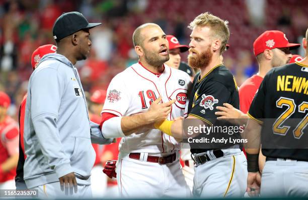 Joey Votto of the Cincinnati Reds is restrained by Colin Moran of the Pittsburgh Pirates during a bench clearing altercation in the 9th inning of the...