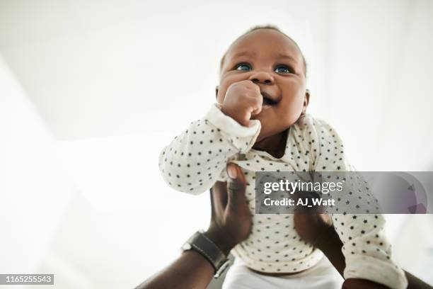 babys sind unbezahlbare geschenke von oben - black man holding baby stock-fotos und bilder