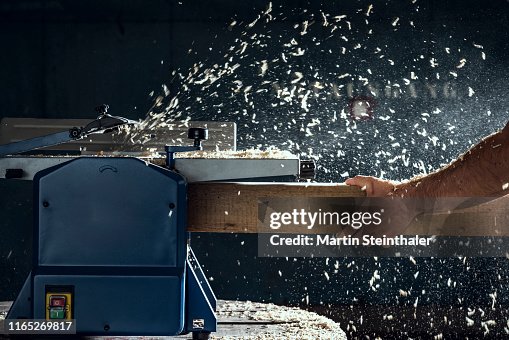 Holz in elektrischer Hobelmaschine - fliegende Späne Holz in elektrischer Hobelmaschine - fliegende Späne