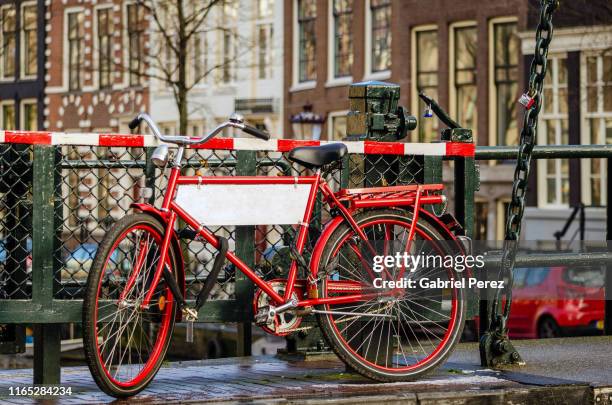 a red bicycle in amsterdam - raduno stock-fotos und bilder