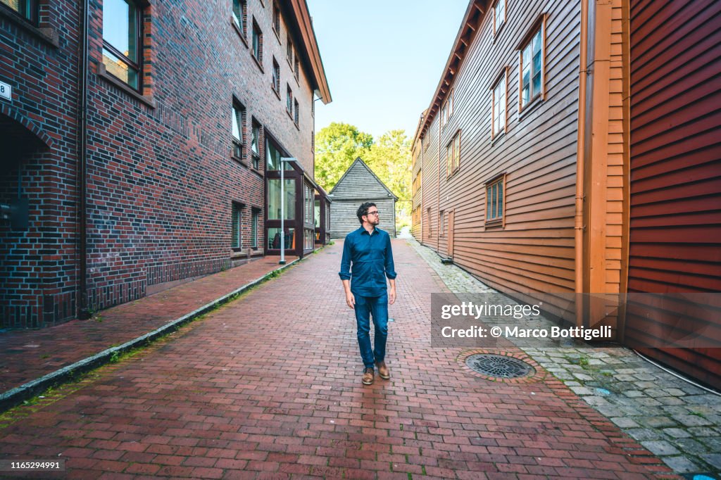 Tourist admiring the unique Bryggen's quarter architecture, Unesco Site. Bergen, Norway.