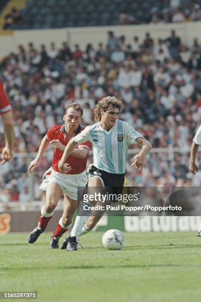 Dario Franco of Argentina pictured making a run with the ball as David Platt of England chases during play between England and Argentina in the 1991...
