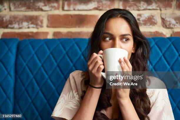 young woman relaxing with a cup of coffee - kaffee genießen stock-fotos und bilder