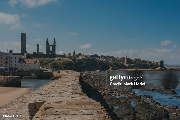 st andrews pier with cathedral and castle visible in the background - st andrews schotland stockfoto's en -beelden