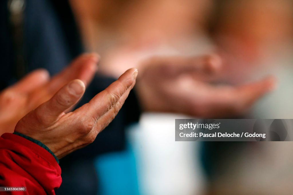 Roman catholic mass.  Man praying.  Pater Noster. Saint-Nicolas de Veroce church. France.