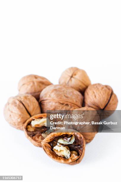 organic walnuts on white background - cáscara de nuez fotografías e imágenes de stock