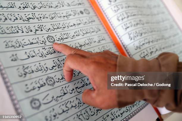 masjid nurul naim mosque.  imam reading the  quran. close-up.  arabic calligraphy.  phnom penh. cambodia. - arabic calligraphy stock pictures, royalty-free photos & images