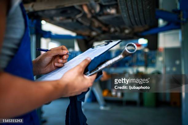 automotive specialist adjusting an engine - lijst document stock pictures, royalty-free photos & images