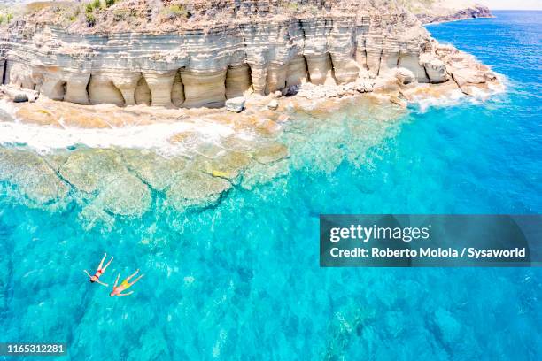 couple floating in sea, pillar of hercules, antigua - antigua and barbuda stock pictures, royalty-free photos & images