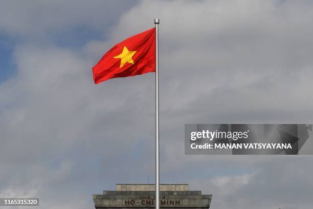 This photograph taken on August 28, 2019 shows a Vietnamese national flag fluttering in the wind outside the Ho Chih Minh mausoleum in Hanoi. - The...