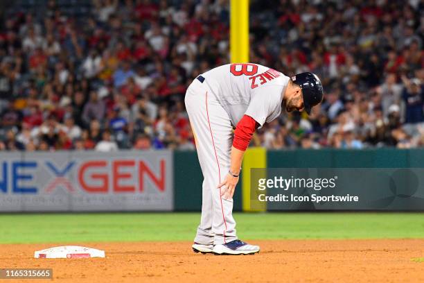 Boston Red Sox right fielder J.D. Martinez holds his knee after hurting it on a slide into second base during a MLB game between the Boston Red Sox...