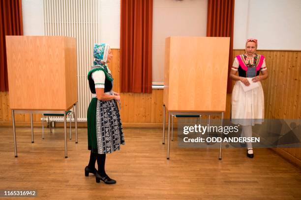 Sylvia Panoscha and her daughter Juliane wearing traditional Sorbian dresses leave a voting booth prior to cast their ballots for state elections in...