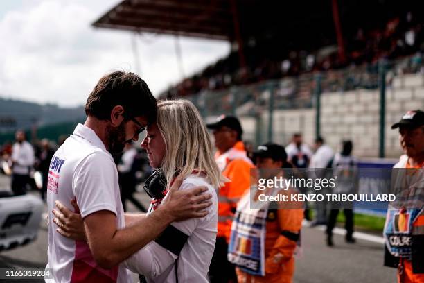 Member of the British formula racing team BWT Arden and a member of the FIA react after a minute's silence before the start of the race of Formula3...