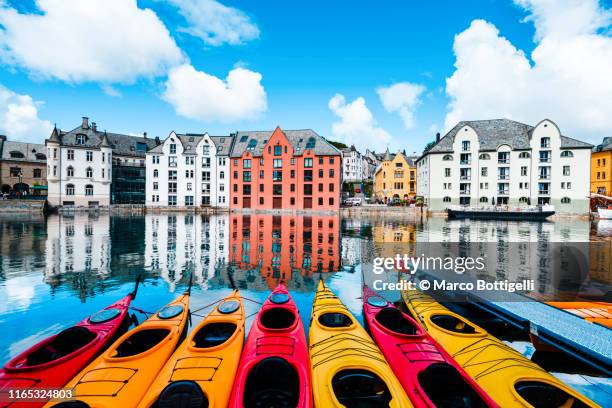 art nouveau buildings and colorful kayaks along the banks of the alesund canal, norway - norwegian culture ストックフォトと画像
