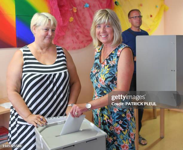 Top co-candidate in Brandenburg of the left wing Die Linke party Kathrin Dannenberg stands next to election officer Ines Labes as she casts her...
