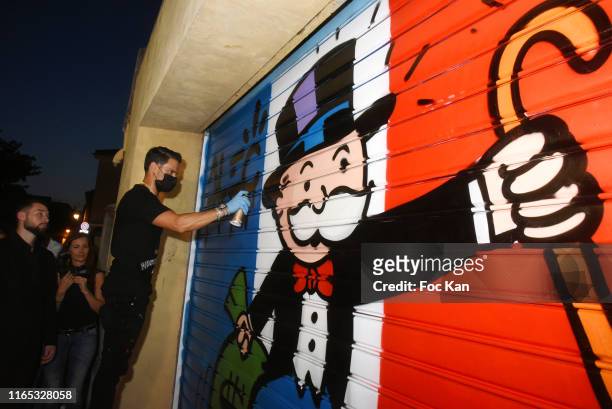 Street artist Alec Monopoly performs during the Alec Monopoly Performance Party At Gallery Bel-Air Fine Art Saint-Tropez on July 30, 2019 in...
