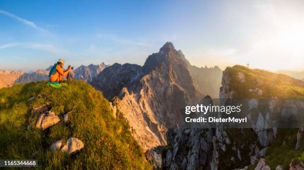 fotógrafo de montaña al amanecer con vista a watzmann y la cumbre cruz del monte groser hundstod - alpes de bavaria fotografías e imágenes de stock