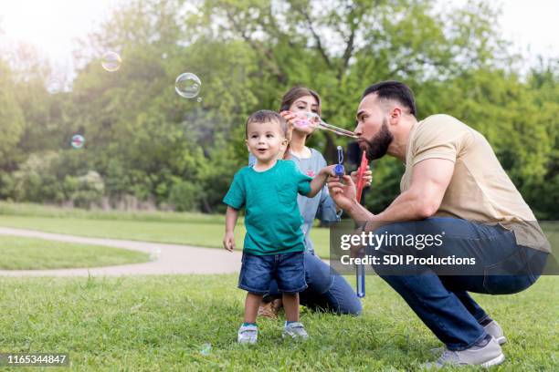 dad plays with son in the park - uncle nephew stock pictures, royalty-free photos & images