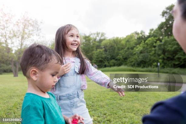 adorable niña sonrisas con deleite mientras juega con burbujas - niece fotografías e imágenes de stock