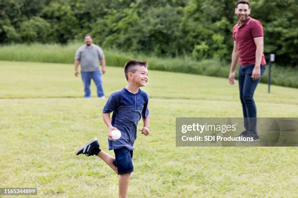 chico alegre juega béisbol con la familia - prima base fotografías e imágenes de stock