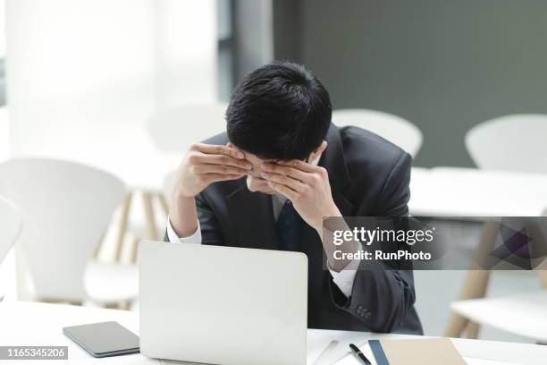 businessman with headache in office - 悩む ストックフォトと画像